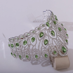 Close-up of silver tiara featuring green teardrop crystals and white rhinestones