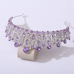 Detailed view of silver crown with large purple crystals and sparkling rhinestones