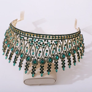 Detail of baroque tiara showing emerald green gemstones and ornate cascading drop crystals