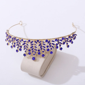 Detailed view of elegant gold tiara with deep blue rhinestones on a display stand