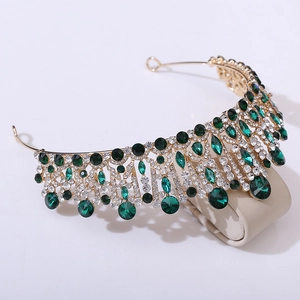 Close-up of gold baroque bridal tiara with green crystals and sparkling rhinestones