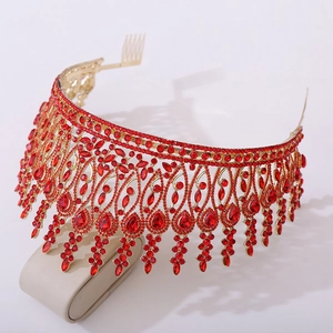 Close-up of golden baroque pageant crown with red rhinestones and integrated hair comb