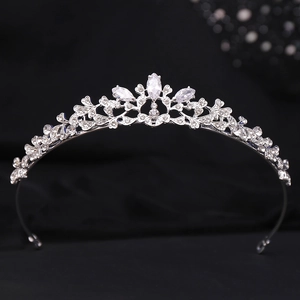 Detailed macro view of silver tiara showing leaf patterns and shiny marquise rhinestones