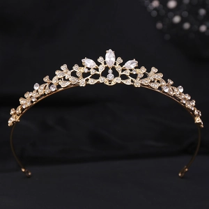 Elegant gold leaf crown with white zircon and rhinestones on a black background