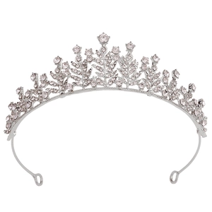 Detail of silver bridal crown featuring leaf textures and sparkling crystals on white background