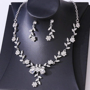 Close-up of bridal rhinestone necklace and earrings set featuring floral leaf designs