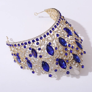 Detail shot of luxury golden crown with deep blue rhinestones and crystal leaf patterns
