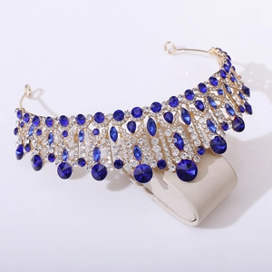 Close-up of golden alloy bridal crown featuring deep blue crystals and white rhinestones