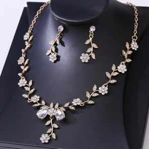 Close-up of golden floral bridal jewelry set with sparkling rhinestones and teardrop stones