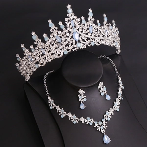 Close-up of bridal jewelry set with silver crown, necklace, and blue rhinestone earrings