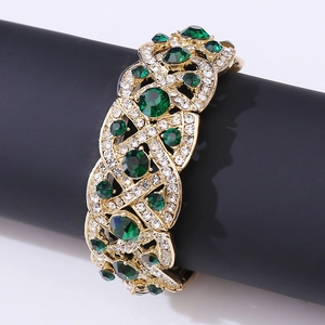 Vintage wide gold cuff bracelet with emerald gemstones and intricate hollow weave design