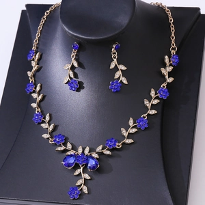 Detailed view of bridal jewelry set with blue rhinestone flowers and leaf patterns