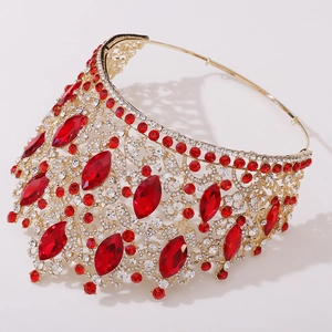 Close-up of European bridal crown featuring red marquise rhinestones and gold leaf filigree