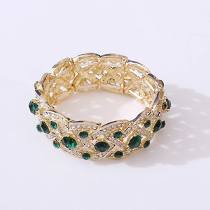 Detail of gold-tone elastic bridal bracelet with green gemstones and white rhinestones