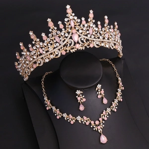 Detail of bridal jewelry set with crown, pink gems, and leaf pattern on display