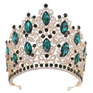Detail of luxury gold bridal crown with emerald green stones and intricate filigree work