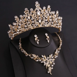 Macro shot of gold bridal jewelry set featuring crystal leaf necklace and crown