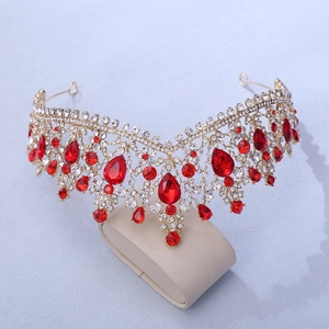 Detail of luxury bridal crown with red teardrop rhinestones on gold frame
