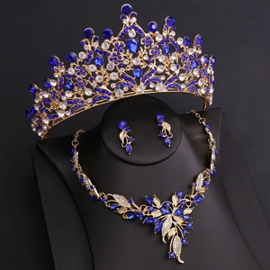 Macro detail of bridal jewelry set featuring blue crystals and gold leaf patterns