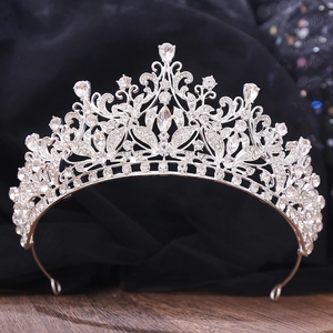 Close-up of silver bridal crown featuring intricate floral patterns and pear-shaped crystals