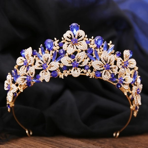Macro shot of gold leaf crown detailing with white rhinestones and dark blue teardrop gems