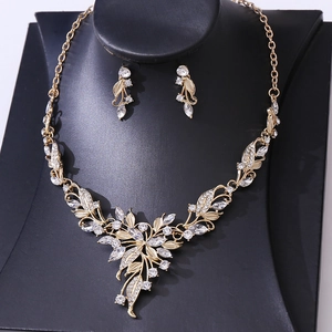 Macro detail of luxury gold bridal necklace and earrings set with crystal leaf patterns