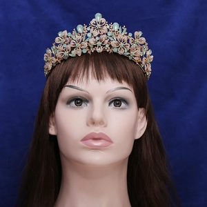 Elegant gold leaf crown with sparkling rhinestones and green teardrop gems for bridal wear