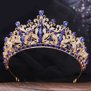 Detailed close-up of a gold bridal crown with blue gemstones and white rhinestones
