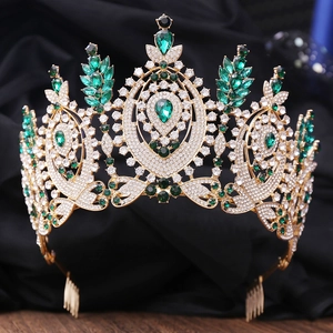 Detail of baroque gold crown with emerald green stones and white rhinestones