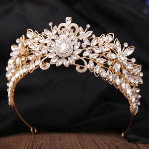 Gros plan sur le diadème de mariée doré avec détails floraux en cristal et pierre en goutte