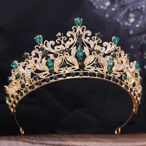 Detailed macro of gold vintage crown with emerald green gemstones and crystal inlay