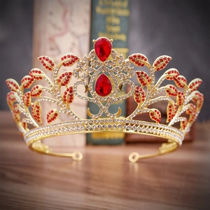 Detailed macro view of luxury golden bridal crown with red rhinestones and leaf design