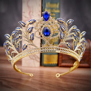 Close-up of golden Baroque bridal tiara with blue leaf-shaped gems and teardrop stones