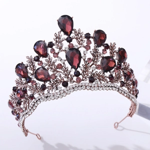 Detail view of vintage baroque crown featuring dark red crystals and intricate metalwork