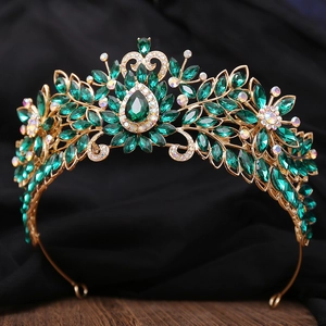 Détail d'une couronne dorée vintage ornée de cristaux vert émeraude et de pierres