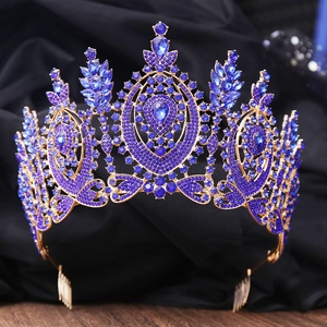 Close-up of golden baroque crown featuring royal blue crystals and intricate palace style detail