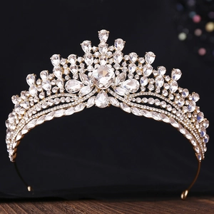 Gros plan d'un diadème de mariée doré avec cristaux scintillants et motifs de diamants fins