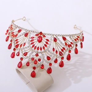 Detailed macro of vintage gold crown with red crystals and dangling water-drop gems