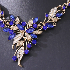 Luxurious gold necklace with blue marquise crystals and white leaf patterns