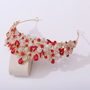 Macro detail of baroque gold tiara featuring sparkling red gems and leaf crystals