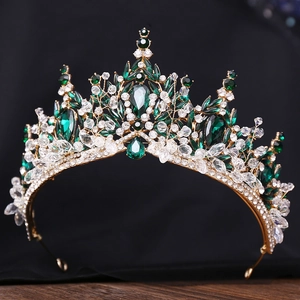 Makroaufnahme der goldenen Barockkrone mit Smaragdkristallen und Strass auf Holz