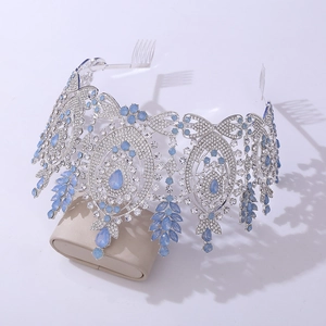Detail of silver bridal crown with blue rhinestones and teardrop pendants on soft cushion