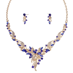Close-up of golden necklace and earrings set with blue marquise crystals and diamonds