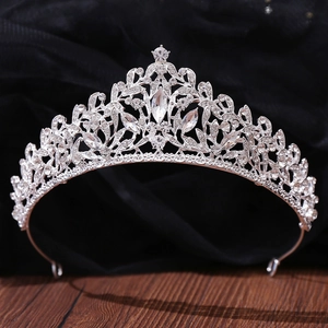 Close-up of silver bridal crown with intricate leaf design and sparkling rhinestones