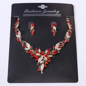 Macro shot of gold bridal jewelry set with red leaf crystals and white rhinestones