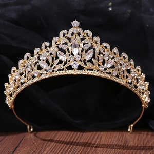 Close-up of golden Baroque crown with white crystals on a premium wood and cloth background