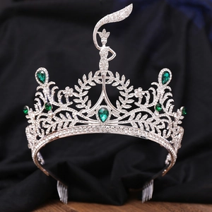Close-up of silver tiara with green emerald gemstones and intricate zircon detailing