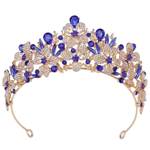 Detailed macro view of baroque crown featuring deep blue gemstones and gold leaf patterns