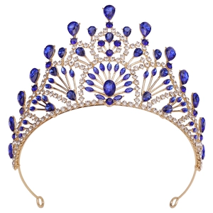 Baroque gold bridal crown with blue gemstones and sparkling rhinestones on white backdrop