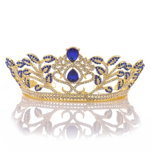 Macro detail of golden baroque bridal crown with blue teardrop crystals and vine leaves